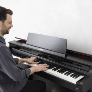 Ein Mann sitzt am Ansicht vom Casio AP-550 und übt
